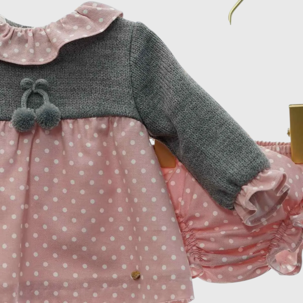 Miniloo grey knit top with pink polka dot dress and matching bloomers. Features a ruffled collar and pom-pom detail.